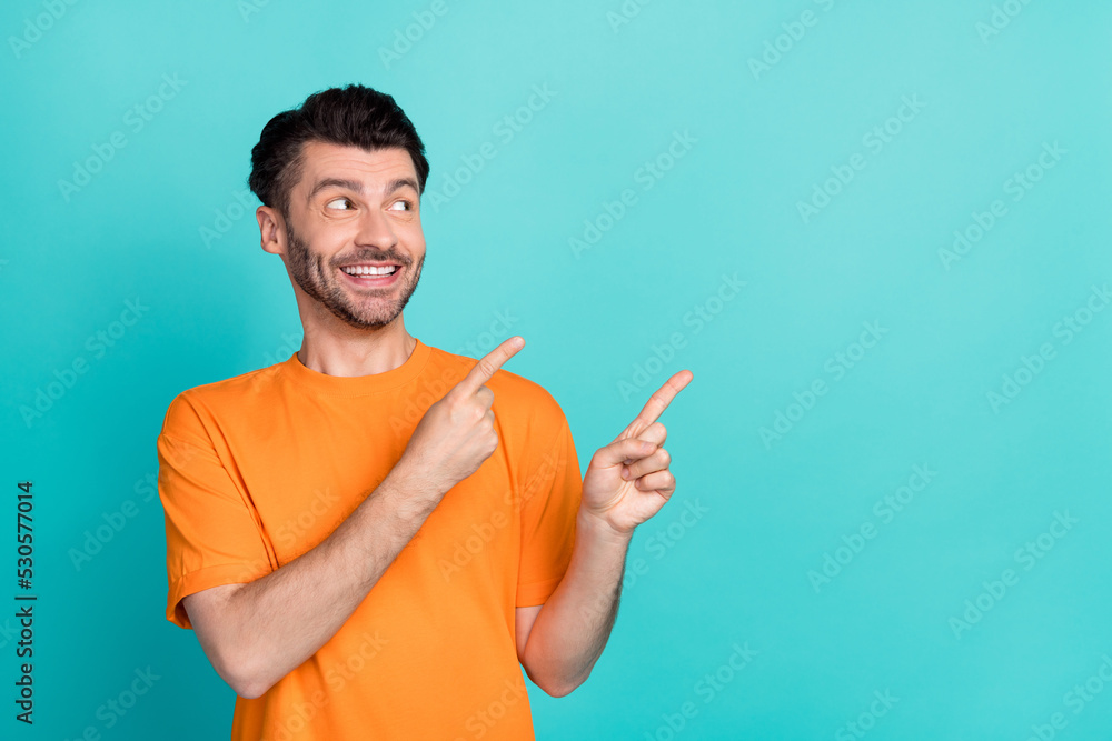 Photo of young attractive handsome funny positive bearded man fingers pointing empty space dreamy interested look isolated on cyan color background Photo of young attractive handsome funny positive bearded man fingers pointing empty space dreamy interested look isolated on cyan color background