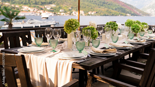 Close-up of a decorated table and a white plate and cutlery. Large table setting for a wedding or birthday.