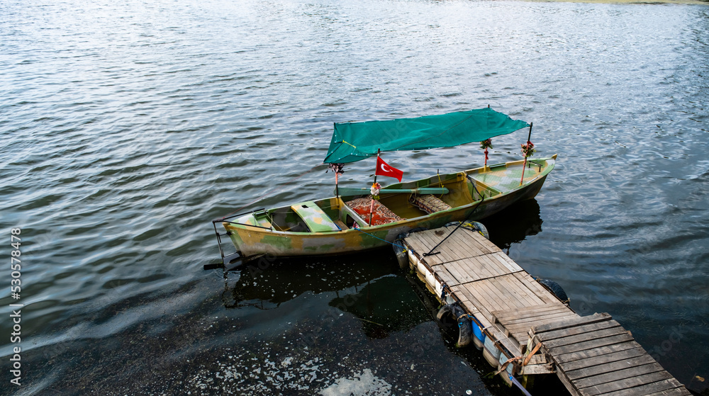 yellow green tour boats on the shore of Lake Apolyont. Uluabat, Golyazı, Bursa, Turkey. Selective Focus Boat.