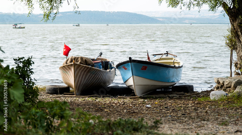 Fishing boats on the shore of Lake Apolyont. Uluabat, Gölyazı, Bursa, Turkey. Selective Focus Boat. photo