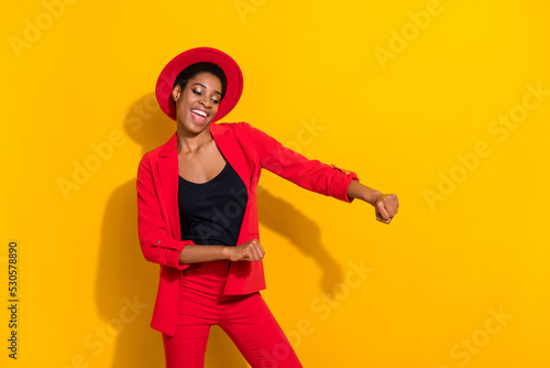 Photo of cute funky short hair person dressed red suit cap smiling dancing isolated yellow color background
