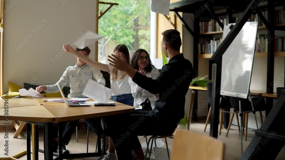 Motivated group enjoys success. Tossing up the paper as a sign of success. Young people and their mentor Motivated group enjoys success. Tossing up the paper as a sign of success. Young people and their mentor