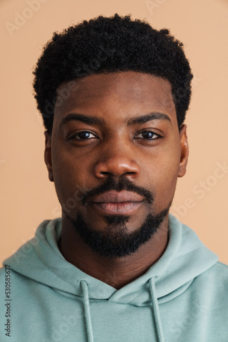 Black young man wearing hoodie posing and looking at camera