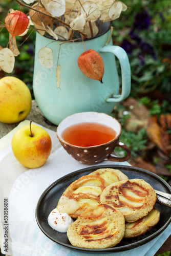 Obraz na płótnie Whole wheat apple pancakes served with tea in the garden. Rustic style. w salonie