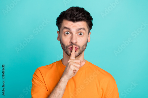 Photo of young attractive handsome funny guy student finger point cover lips shh silence secret information isolated on aquamarine color background