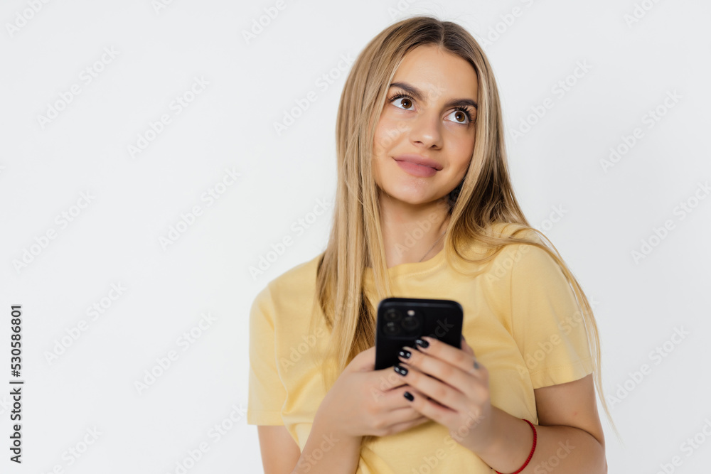 Young woman smiling while using cellphone isolated over white background Young woman smiling while using cellphone isolated over white background