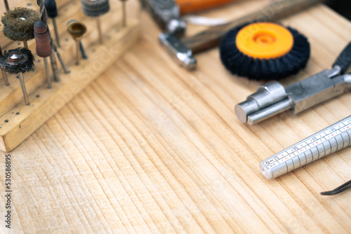 jewelry handmade by experienced goldsmiths with simple tools on wood background top view