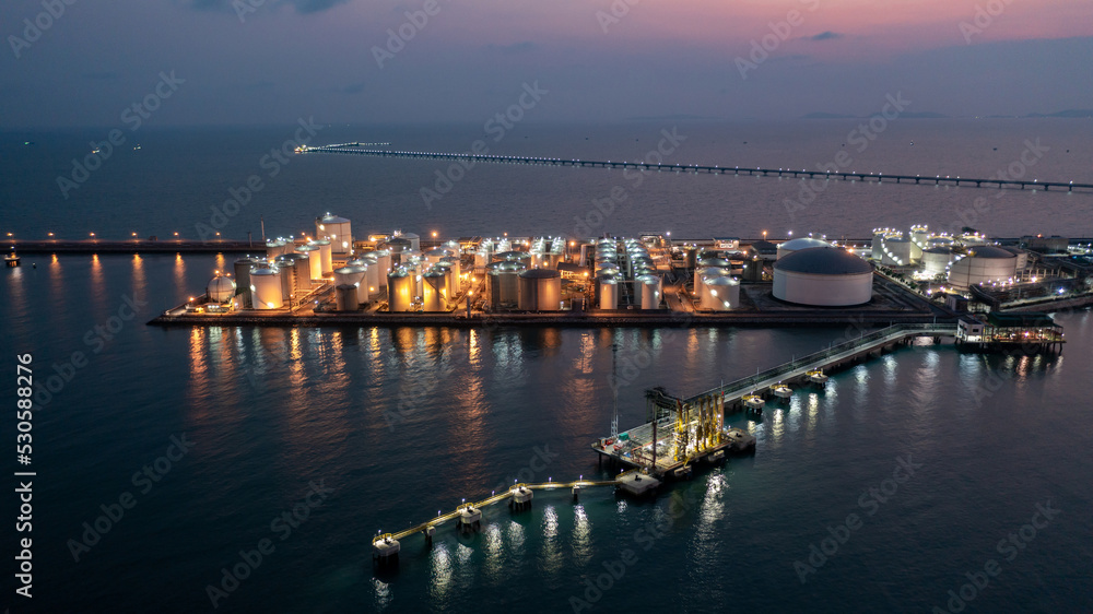 Aerial view chemical storage tank on sea at oil terminal station at night, Chemical plant petroleum and petorchemical product, Chemical industry plant in refinery at night,