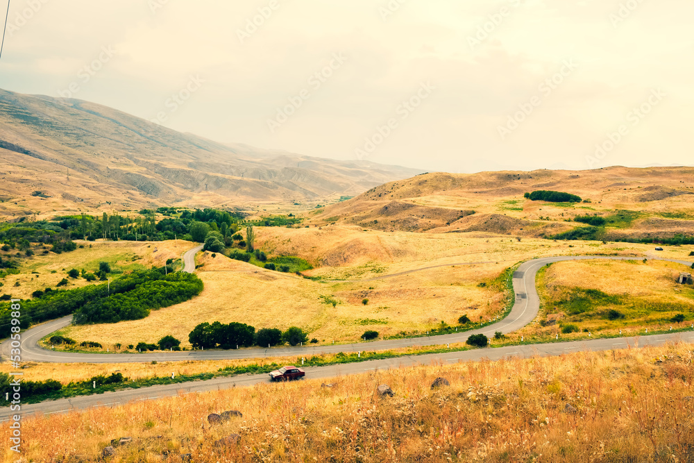 Automobile drive in countryside serpentine road outdoors in nature with scenic mountains panorama. Travel road trip in caucasus- Armenia