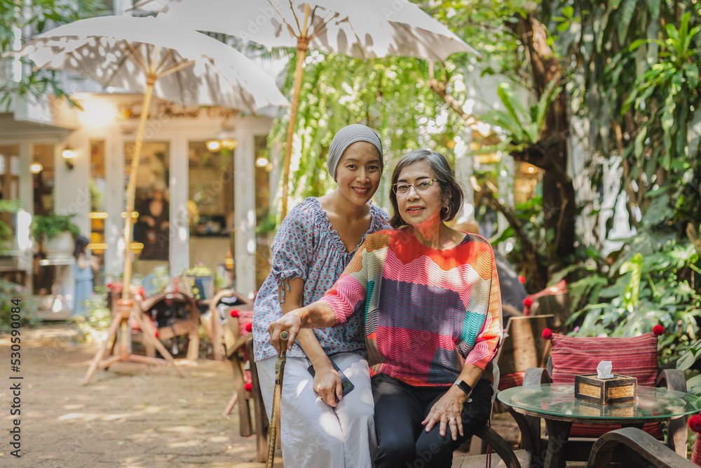 Portrait of beautiful asian senior mother and daughter smiling at the camera.