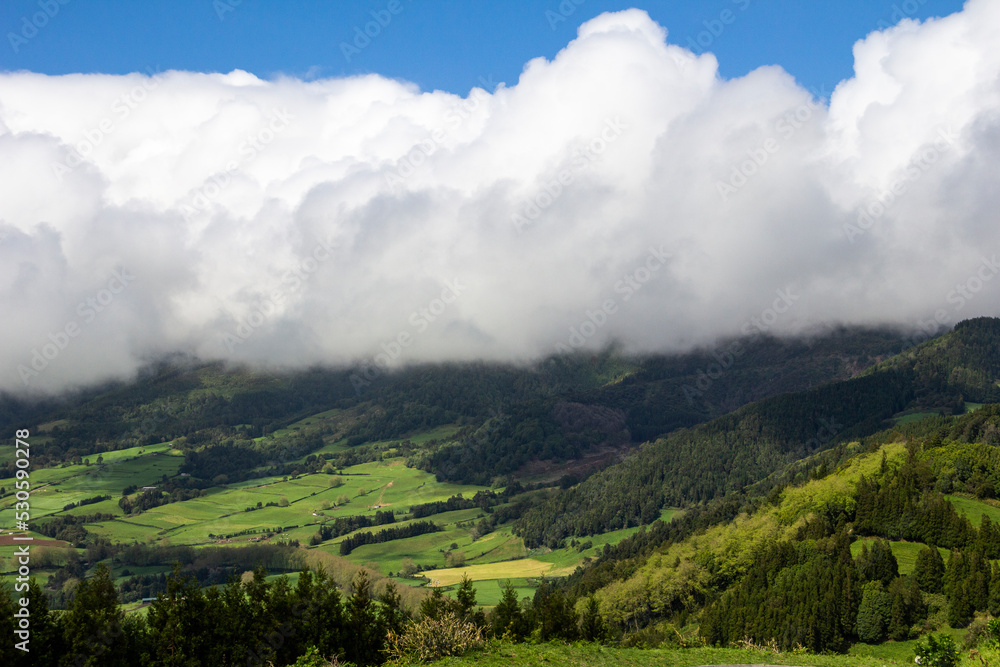 view of the valley of the mountains with white clouds