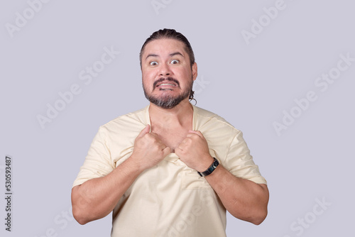 A crazed man pretends to rip his shirt off. An animated guy acting funny. Isolated on a gray background. photo