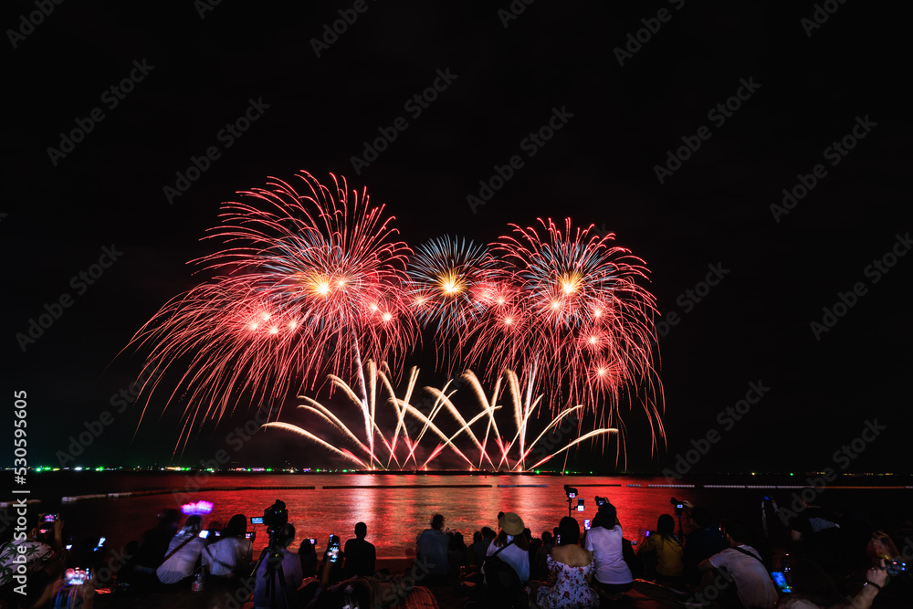 Obraz premium PATTAYA, CHONBURI, THAILAND, - NOVEMBER Beautiful lights at the night, colorful fireworks, at Pattaya International Fireworks Festival and silhouette Group of people tourist