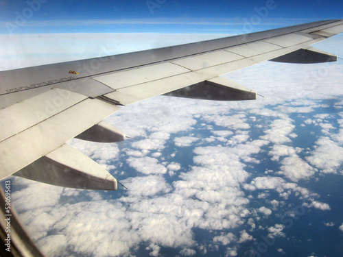View on the wing of the clouds and the sea at a height during the flight 