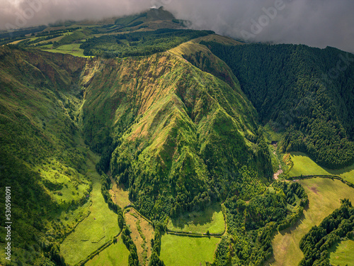 Beautiful volcanic mountain lakes of the Azores islands and surrounding lush green forests  fields and cliffs and the Atlantic ocean.