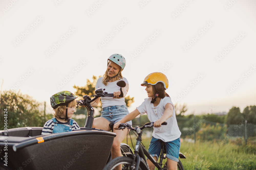 Mother with children cycling in the countryside
