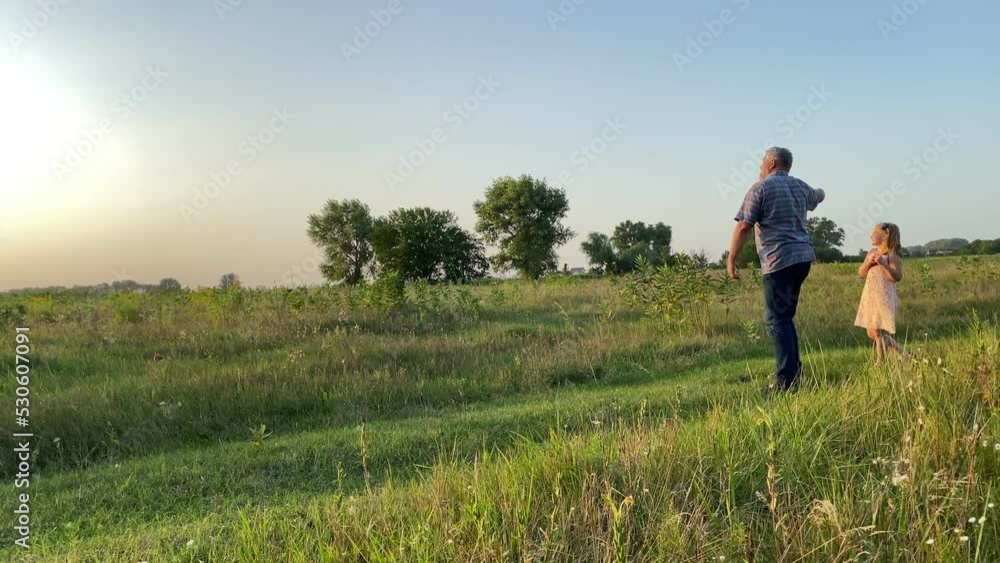 Happy family with two children having leisure together outdoors. Father teaching daughter to fly kite. Little son having fun at field in golden lights of summer sunset. Parent spending time with kids Happy family with two children having leisure together outdoors. Father teaching daughter to fly kite. Little son having fun at field in golden lights of summer sunset. Parent spending time with kids