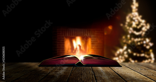 Buch mit Weihnachtsgeschichte vor Kaminfeuer mit unscharfem Hintergrund