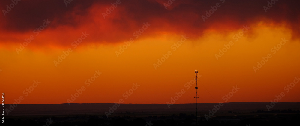 Cell Tower for Digital Communication at Sunset Silhouette