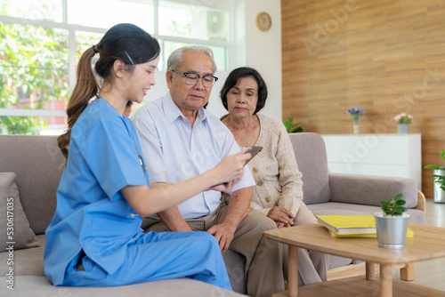 Young female nurse doctor caregiver holding tablet explaining prescription prescribing drug to elderly patient at nursing home. Record check up information. Healthcare pharmacy and insurance service