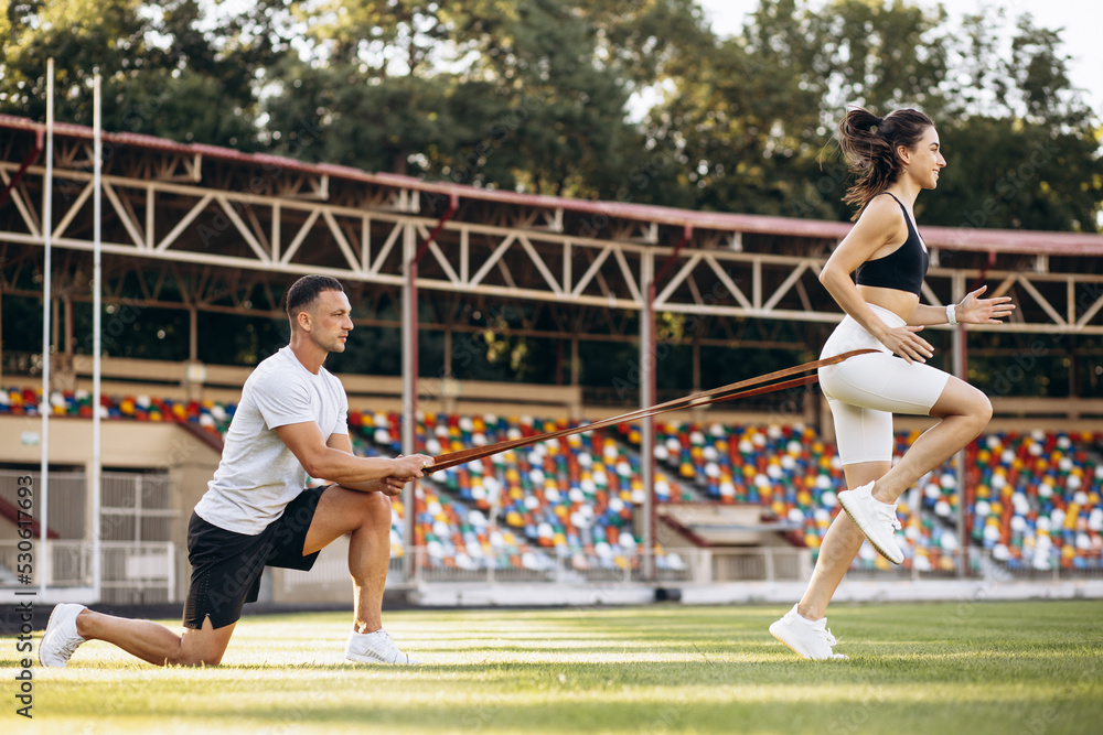 Obraz premium Couple exercising using elastic rope