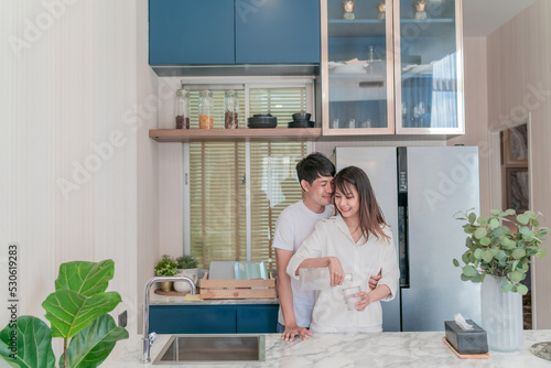 happy asian couple cooking healthy food. smiling boyfriend and girlfriend making breakfast support each other. attractive wife and cheerful husband preparing delightful meal with fresh ingredients