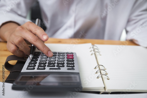 Business woman accountant using calculator on desk. Savings, finances and economy concept.