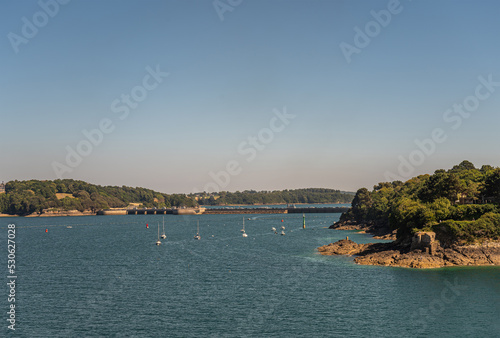 St. Malo, Brittany, France - July 8, 2022: Barrage de la Rance, at the mouth of the river, is a tidal power plant producing electricity and linking 2 neighborhoods. Landscape with blue sky, blue water