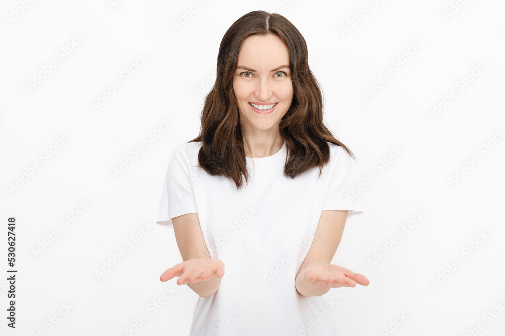 minimal portrait of smiling brunette woman in white T-shirt on white background holds bent arm for advertising goods, copy space, template concept minimal portrait of smiling brunette woman in white T-shirt on white background holds bent arm for advertising goods, copy space, template concept