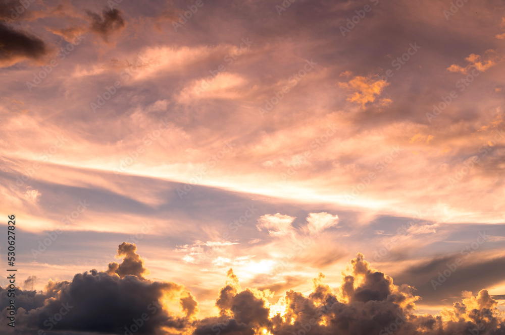 Obraz premium sunset / sun rise sky with rays of yellow and red light shining clouds and sky background and texture