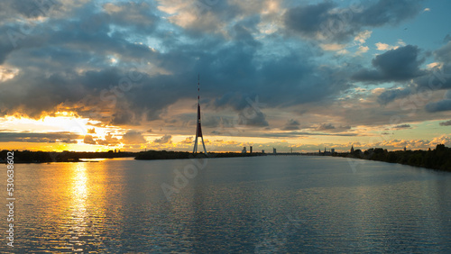 Riga, in the photo panorama of the city in the evening clouds and blue sky in the background, river in the foreground