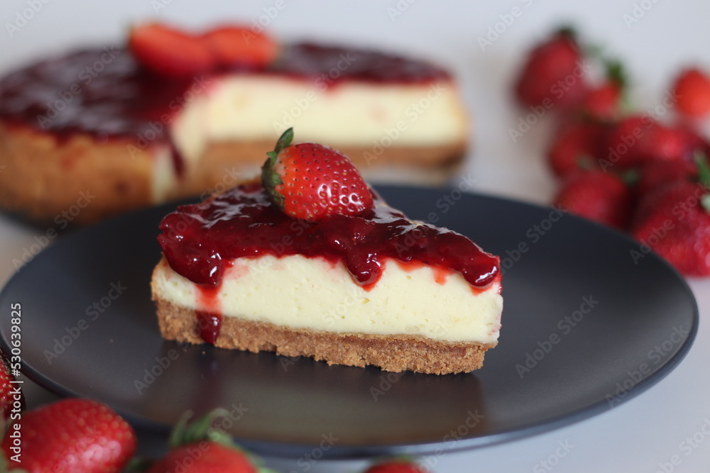 Slice of Strawberry cheese cake. Silky smooth and creamy cheese cake topped with homemade fresh strawberry sauce