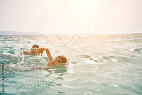 Happy family in swimming goggles, father and son bonding, swim in the sea looking at view enjoying summer vacation. Togetherness Friendly concept