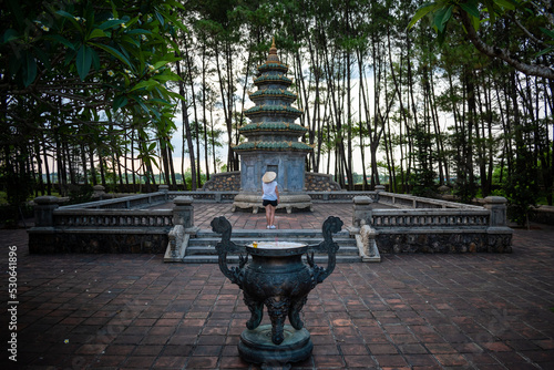 Mujer con sombrero vietnamita descubriendo templo budista en Thien Mu Pagoda photo