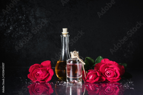 Bottles of perfume and red roses.