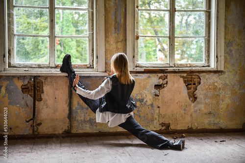 Choreographer girl doing an exercise in an old room of an abandoned house © Raimonds Kalva