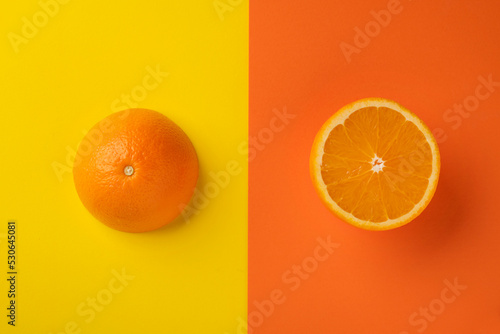 Sliced ​​ripe orange on bright abstract background. Flat composition.