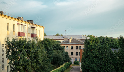 Old Soviet houses in cozy town. Street view landscape old cirty, little houses on sunset. Old Soviet architecture street front view. Calm town street. Calm russiun town street with green trees