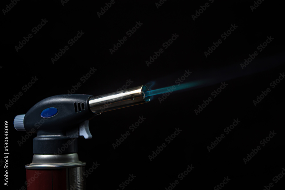 Fire from a gas burner on a black background. Blue fire from a burner Fire from a gas burner on a black background. Blue fire from a burner