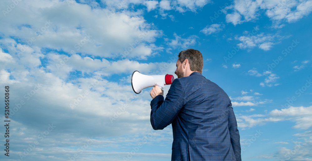 back view of businessman shout in loudspeaker on sky background. copy space back view of businessman shout in loudspeaker on sky background. copy space