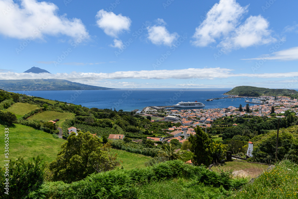 View over Horta to the Pico volcano / View over the town of Horta on the island of Faial, a cruise ship is moored in the harbor, on the horizon you can see the Pico volcano, Azores, Portugal.