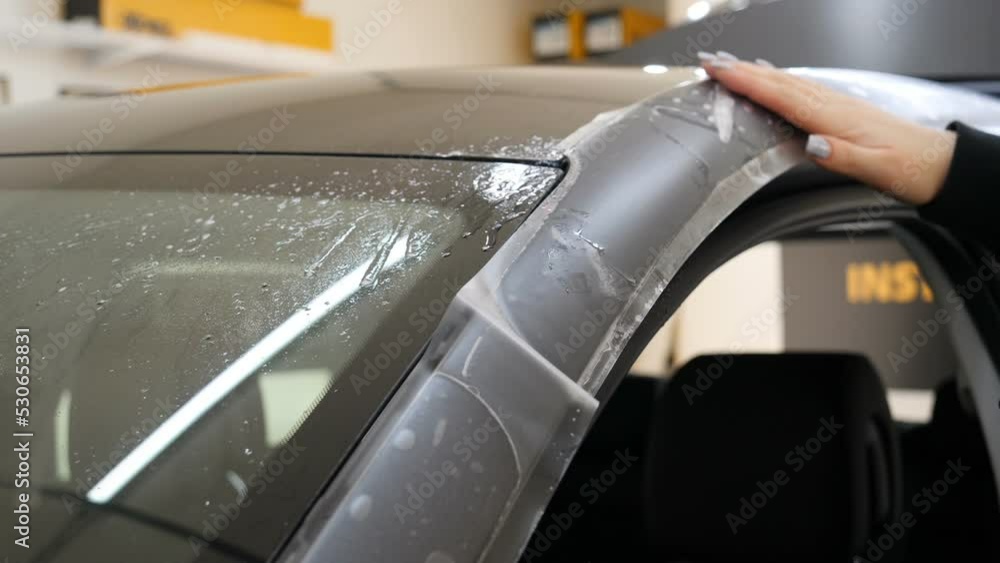 Close up to PPF installation process on a front headlight and hood. PPF
