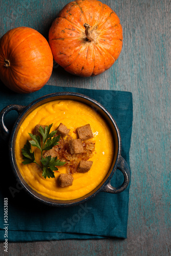 Pumpkin puree with crackers and parsley in a blue bowl