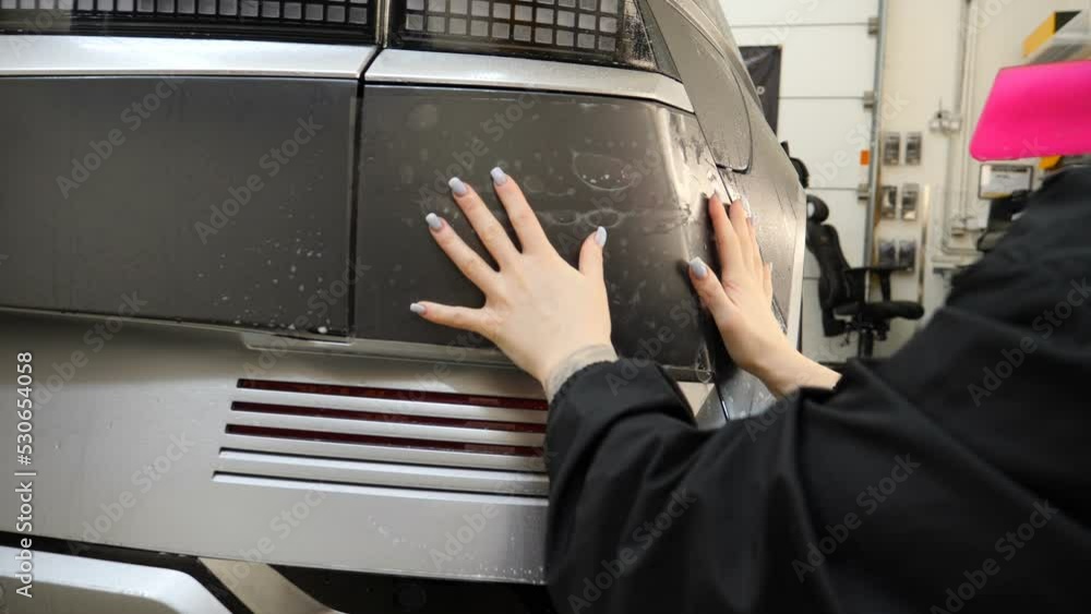 Close up to PPF installation process on a front headlight and hood. PPF