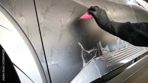 Close up to PPF installation process on a front headlight and hood. PPF is a Paint Protection Film which protect paint from scratches and stone chips. Concept of: Guard, Protect, Car, New, Work.