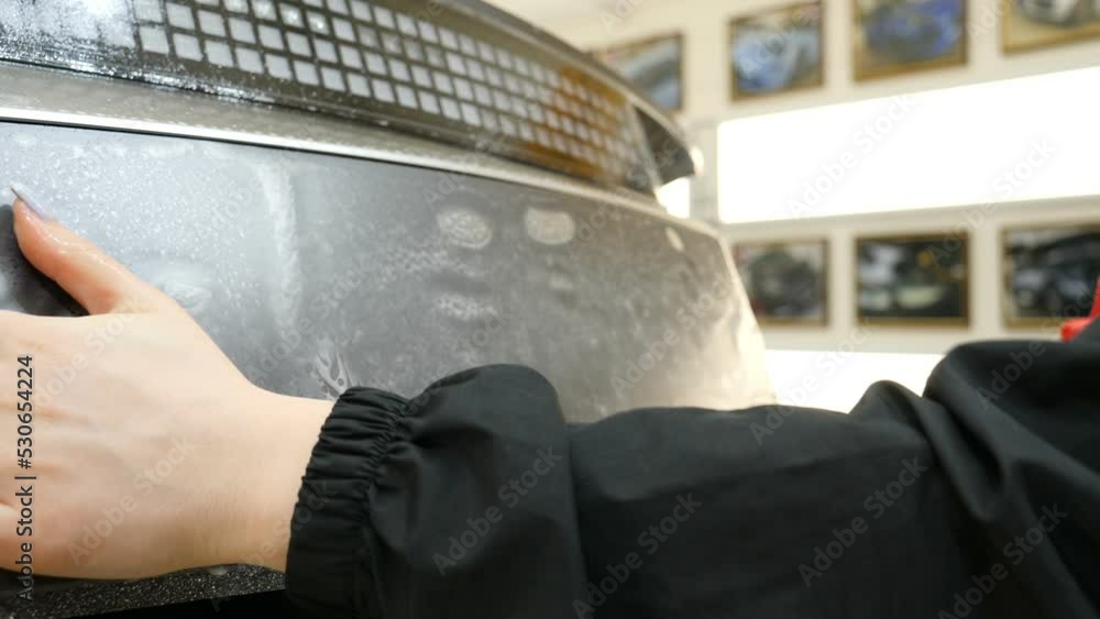 Close up to PPF installation process on a front headlight and hood. PPF