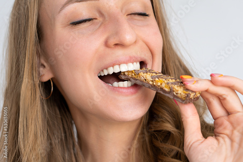 Blonde girl eats puffed corn snacks. Happy man eats dessert. Positive emotions. Beautiful smile. White teeth.