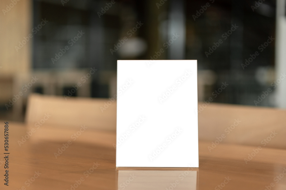 Menu frame with white blank screen on wooden table in restaurant or cafe on bokeh background Menu frame with white blank screen on wooden table in restaurant or cafe on bokeh background
