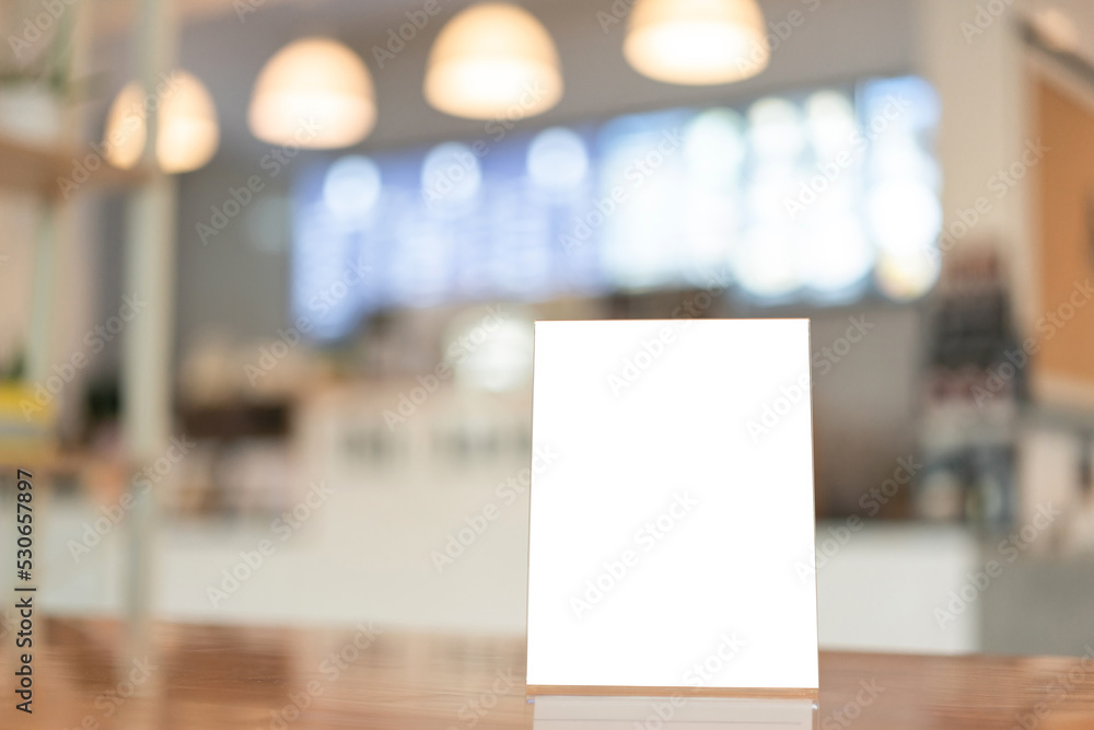 Menu frame with white blank screen on wooden table in restaurant or cafe on bokeh background