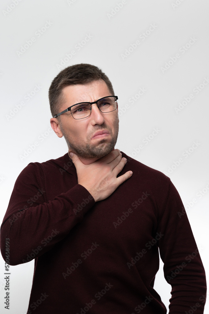 Handsome man wearing glasses over isolated background touching painful neck, sore throat from flu, cold and infection Handsome man wearing glasses over isolated background touching painful neck, sore throat from flu, cold and infection